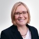 Karin Baas schaut nach vorne und lächelt.